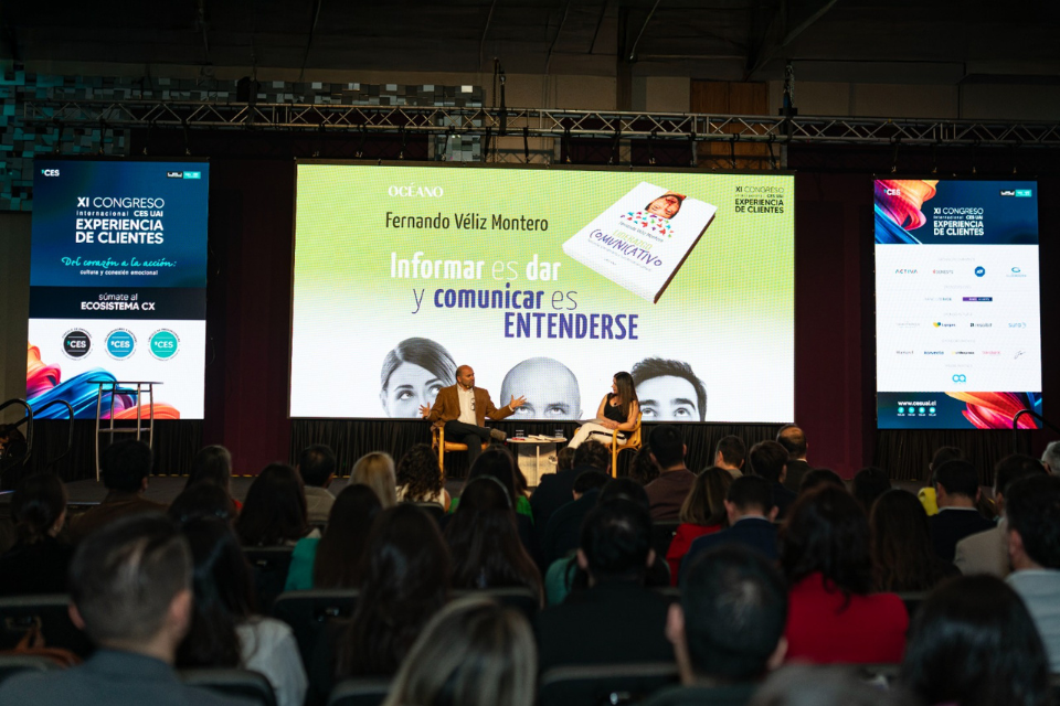 Fernando Véliz Montero ofreciendo una conferencia magistral sobre comunicación y experiencia de clientes frente a una audiencia en un evento internacional.