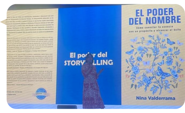 Nina Valderrama presentando su libro "El Poder del Nombre" en una conferencia, con una pantalla de fondo que muestra la portada del libro.