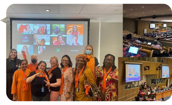 Grupo de mujeres en una conferencia sobre empoderamiento femenino y derechos de género, con una pantalla de videollamada de fondo y un auditorio lleno.