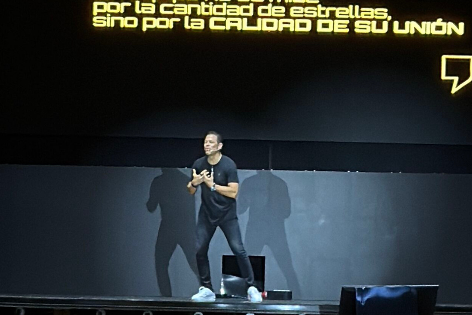 Óscar Córdoba en escenario empresarial compartiendo lecciones de liderazgo bajo presión